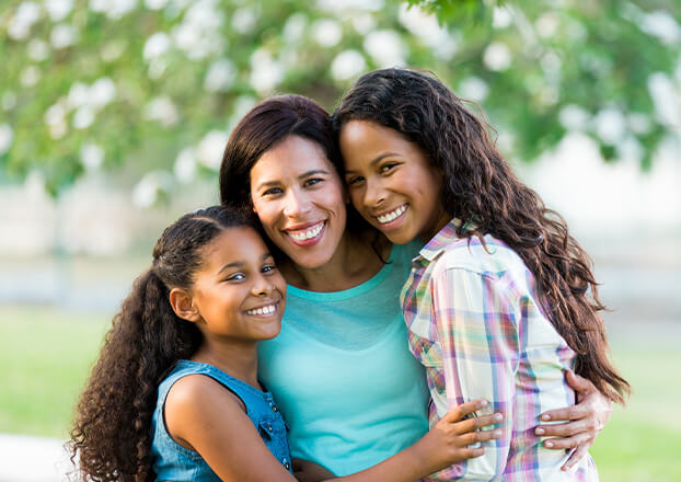 smiling mother with her two daughters